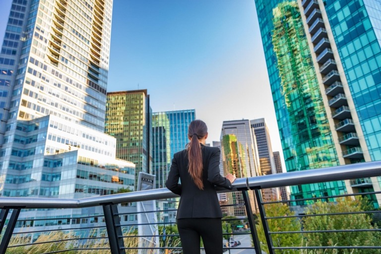 Business woman in city center looking at view of skyline skyscrapers in Vancouver, Canada