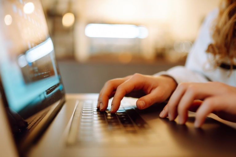 Woman's hands typing on a laptop keyboard